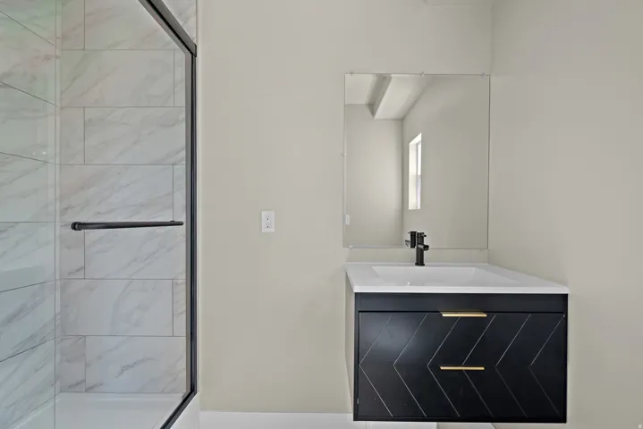 Shower with framed glass enclosure and tile surround