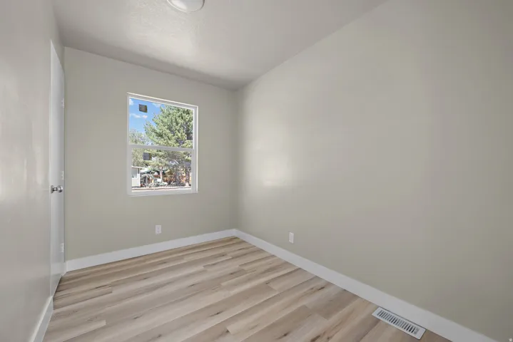 Neutral paint finishes, wood-finish flooring, and a flush mount ceiling light