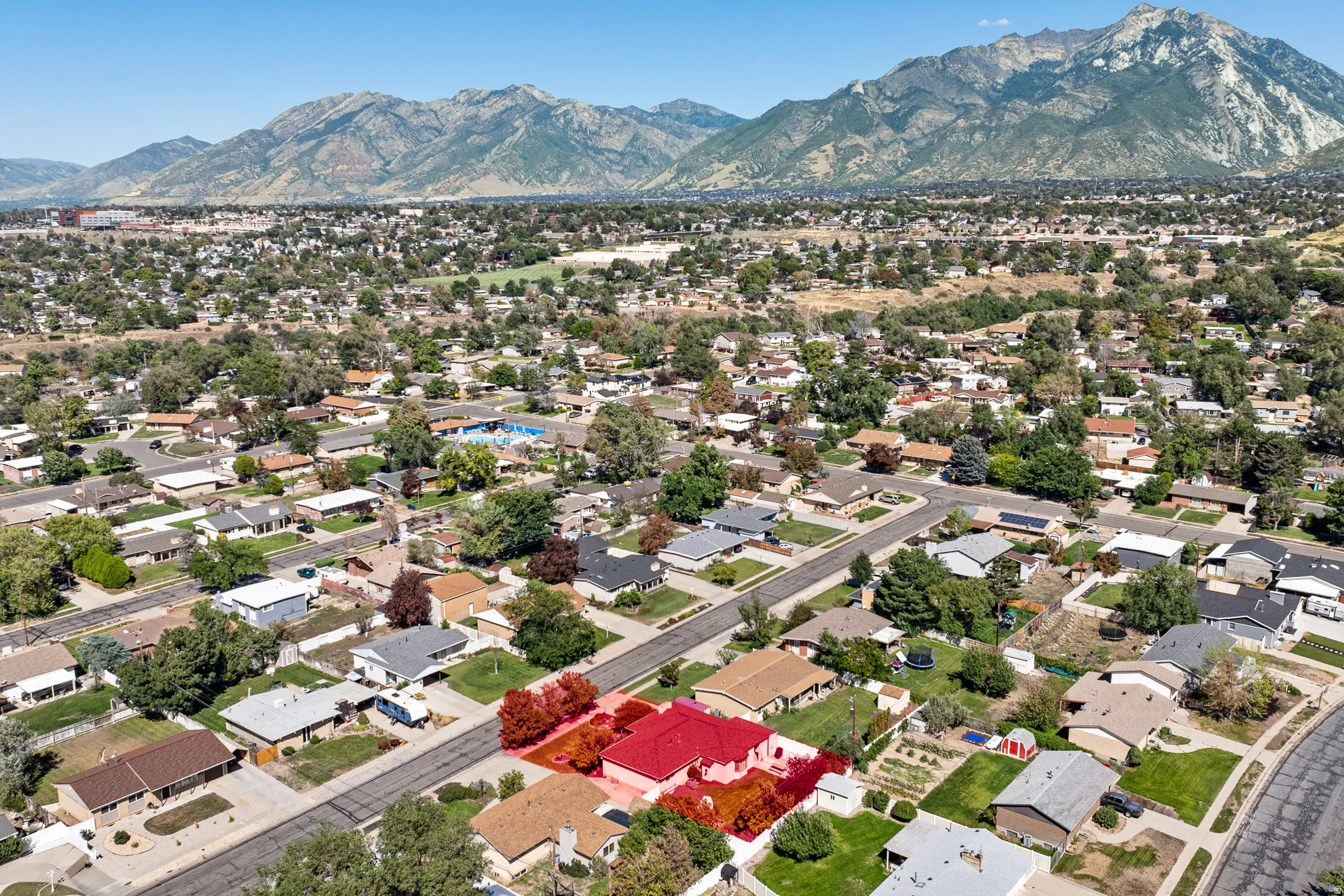 Neighborhood setting with mature trees and mountain backdrop