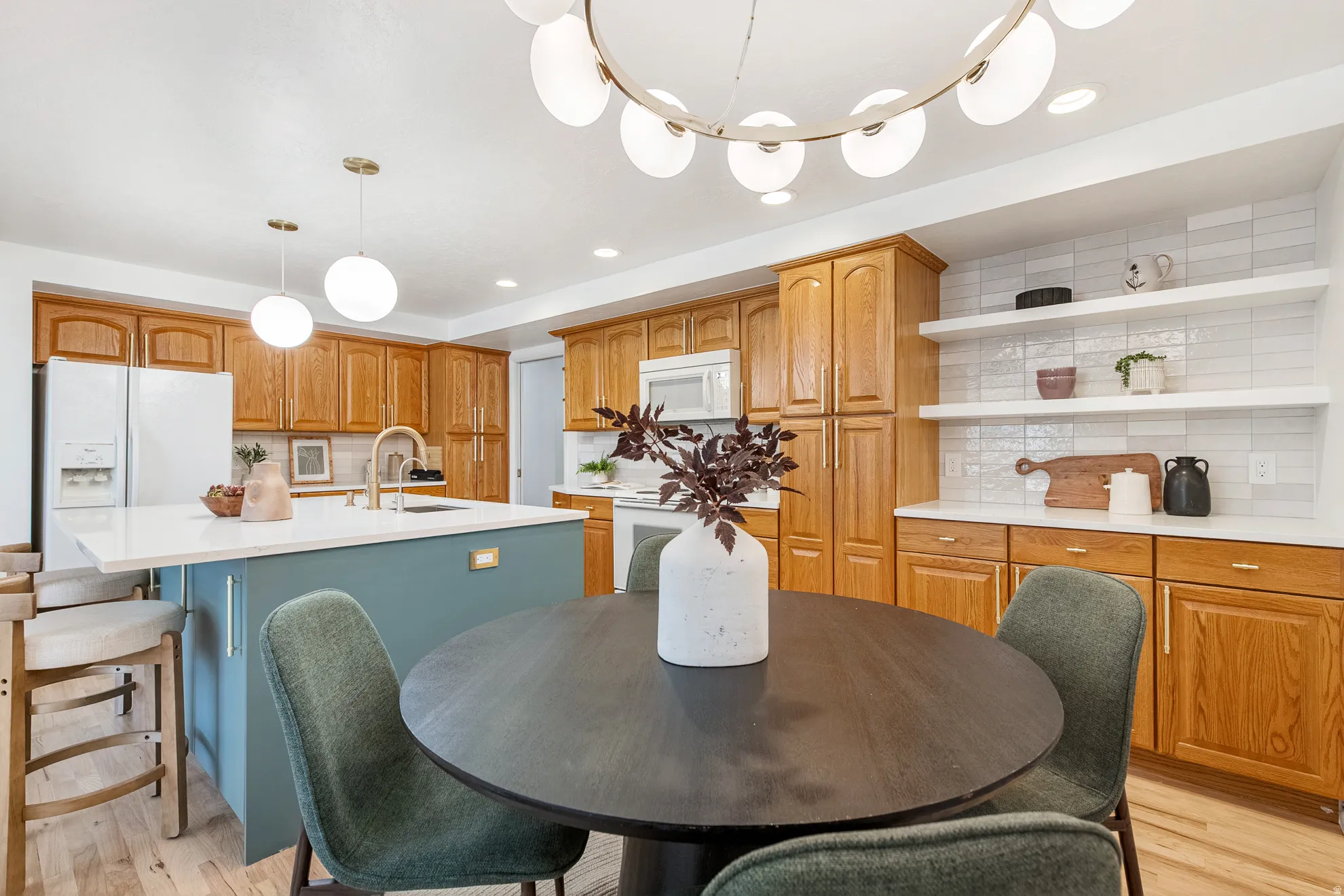 Kitchen featuring wood cabinetry, a center island with countertop seating, a white tile backsplash, and open shelving