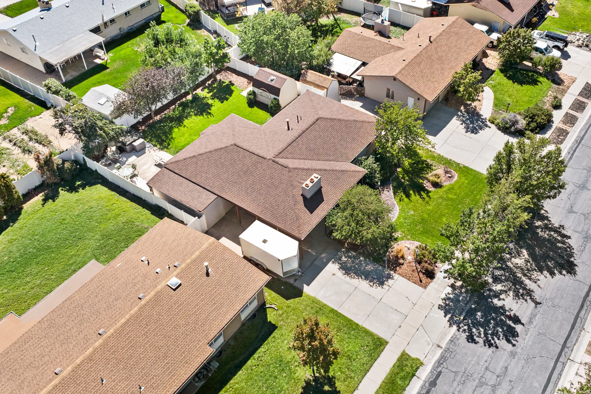 Single-story residence with a brown shingle roof, paved driveway, and established front landscaping