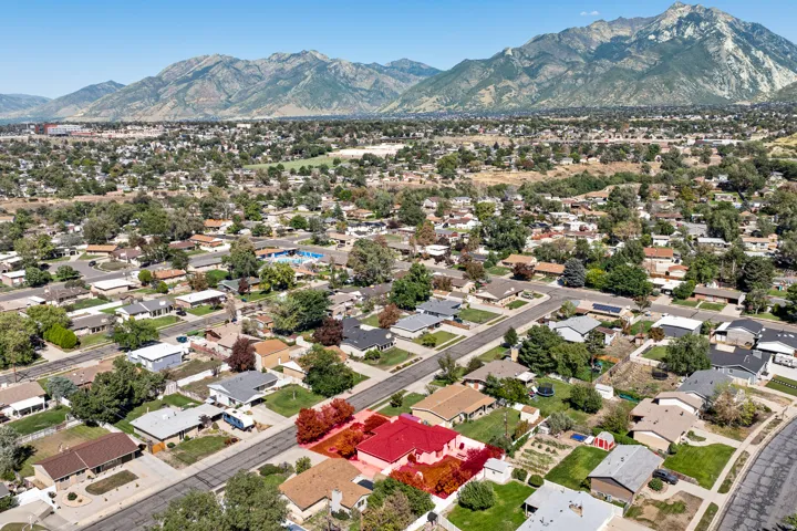 Neighborhood setting with mature trees and mountain backdrop