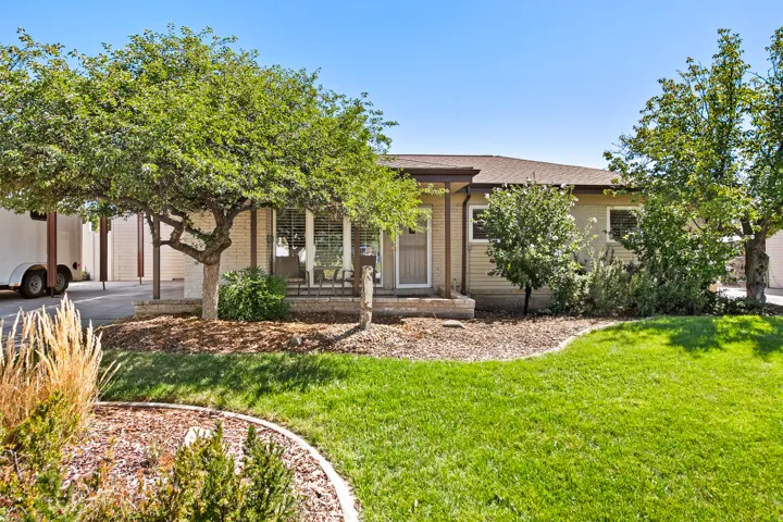 Expansive front lawn with mature trees and landscaped beds