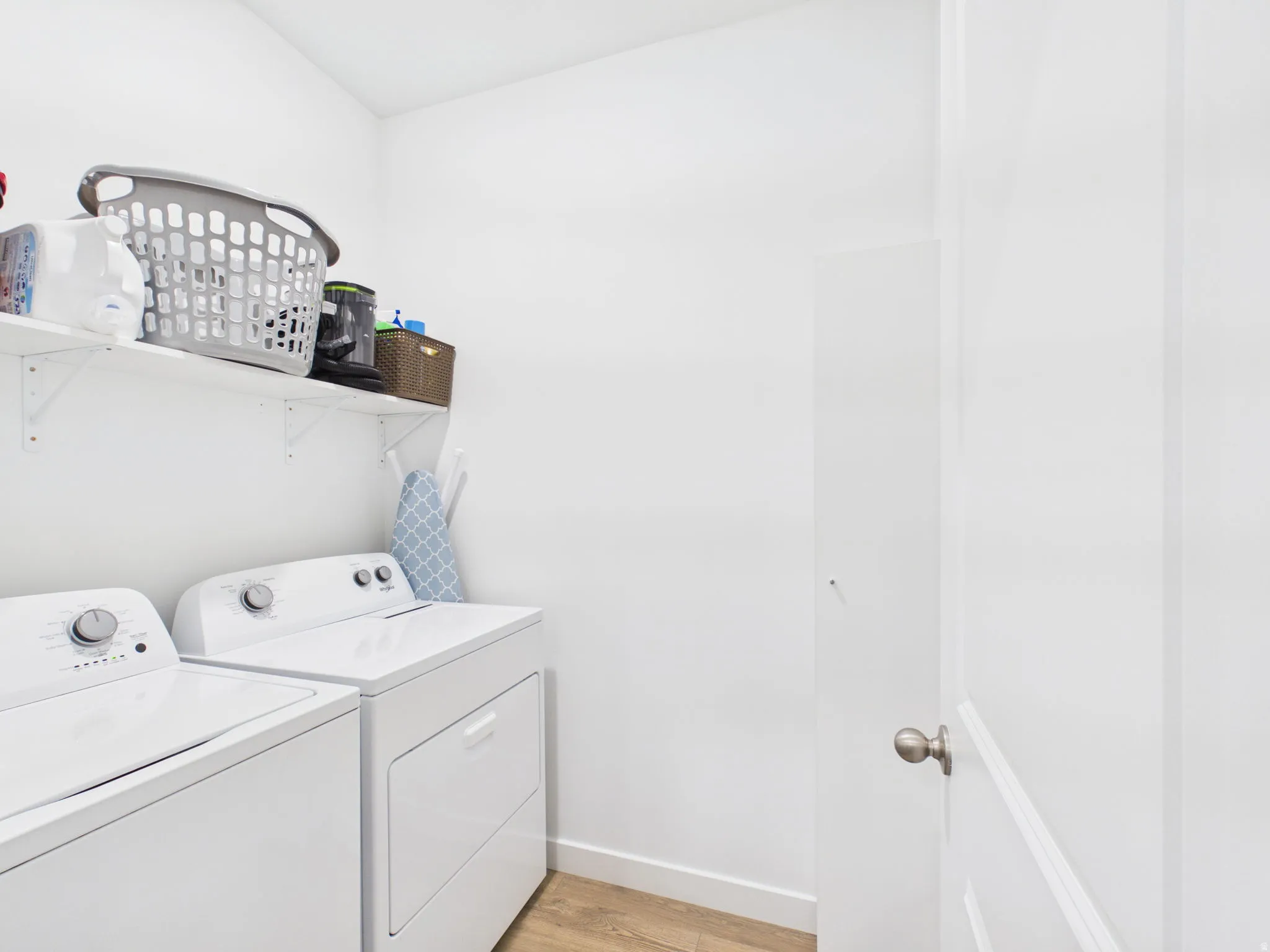 Washer and dryer appliances, shelving for storage, wood-finish flooring