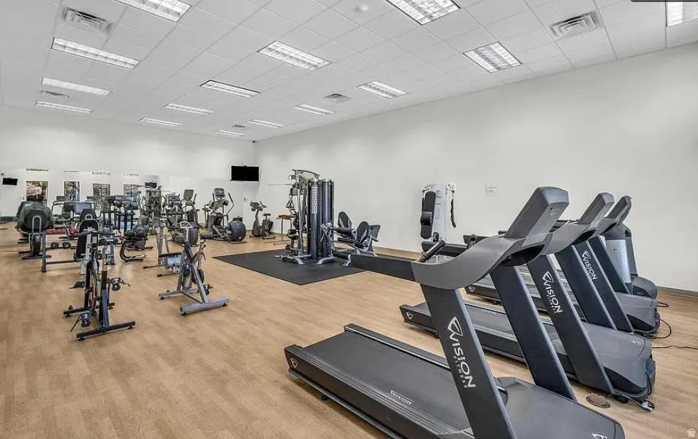 Spacious fitness center featuring wood-finish flooring, recessed lighting, and multiple exercise machines