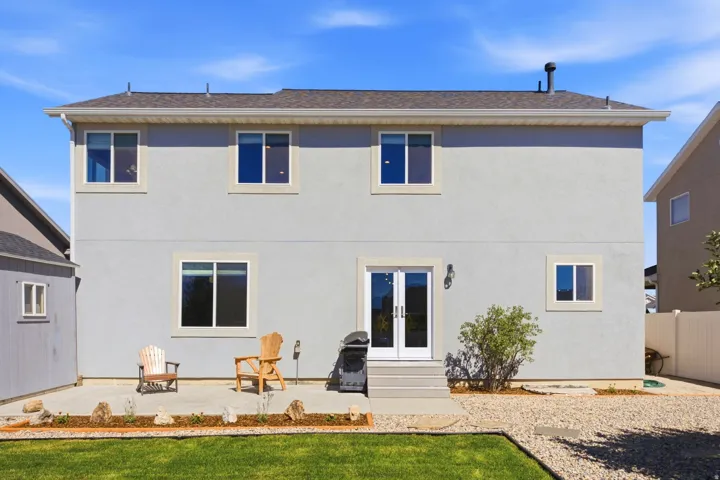 Two-story stucco exterior with multiple windows and a gabled roofline