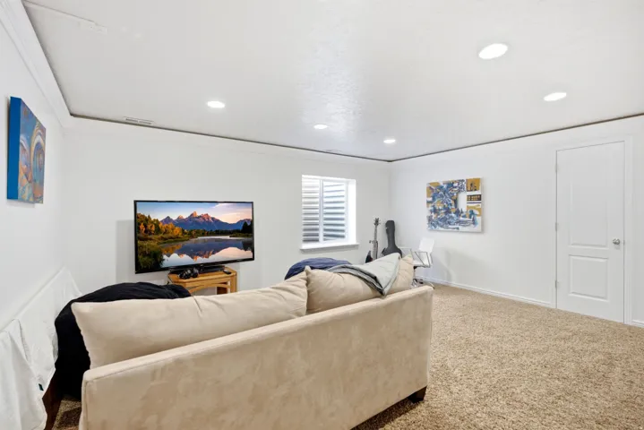 Recessed lighting, crown molding, white walls, carpet flooring, and a window with blinds