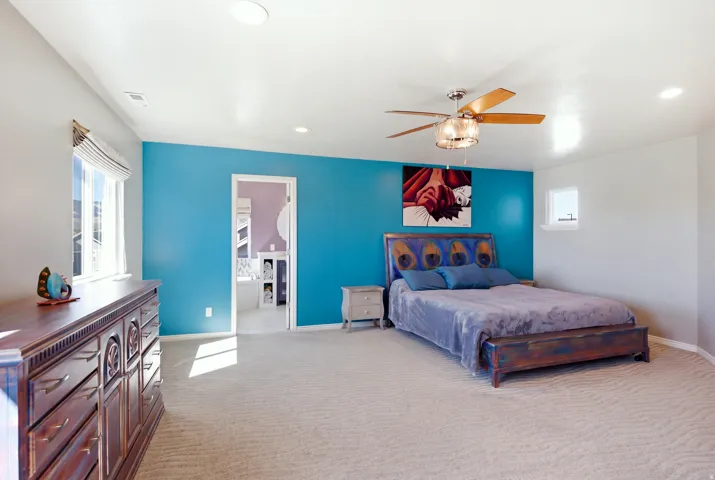 Recessed lighting, ceiling fan light fixture, broad window, and carpeted flooring