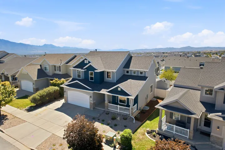 Contemporary two-story residence featuring a covered front porch, an attached two-car garage, and a low-maintenance landscape