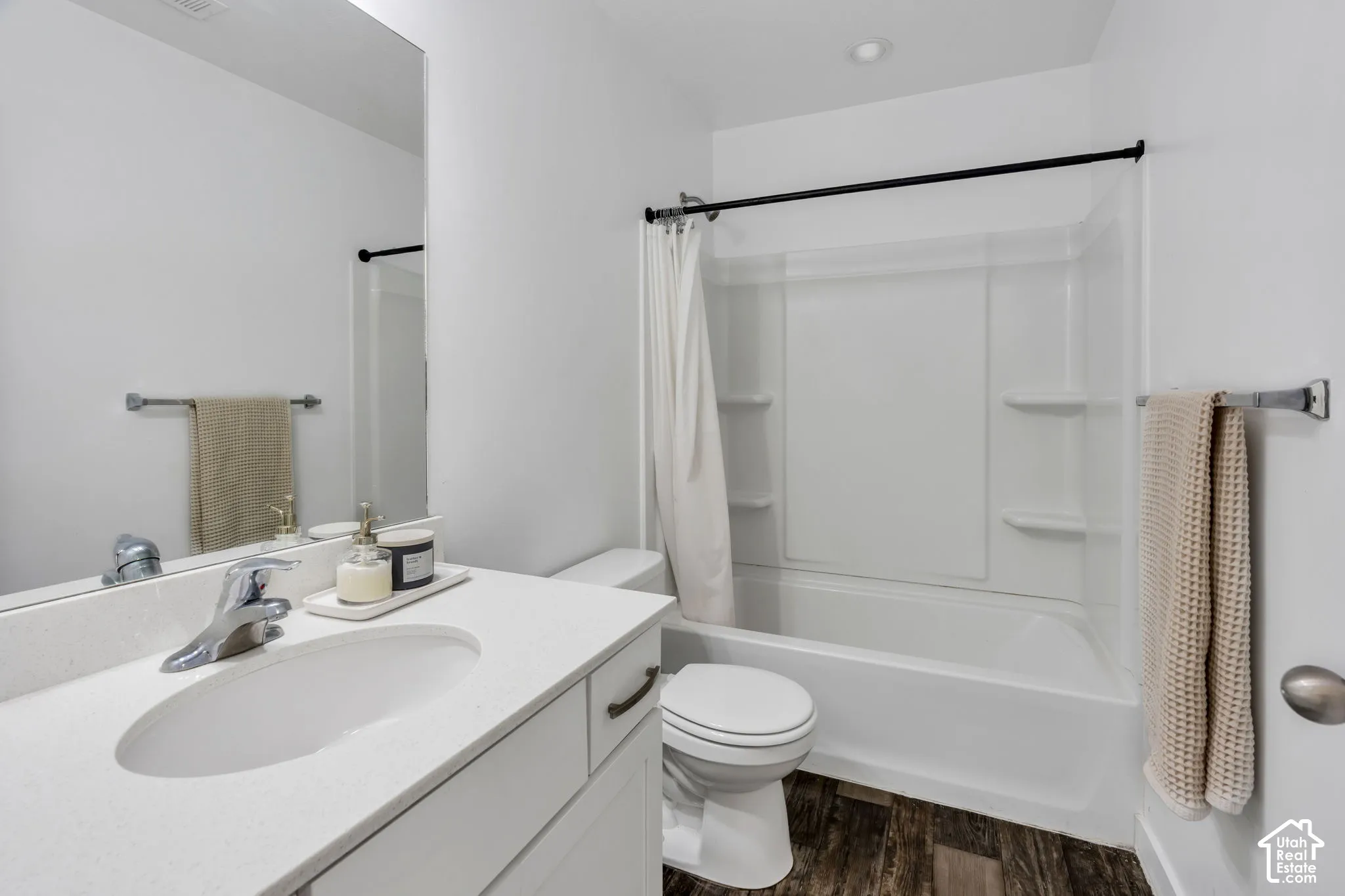 White vanity with an integrated sink, polished chrome faucet, and a large wall mirror