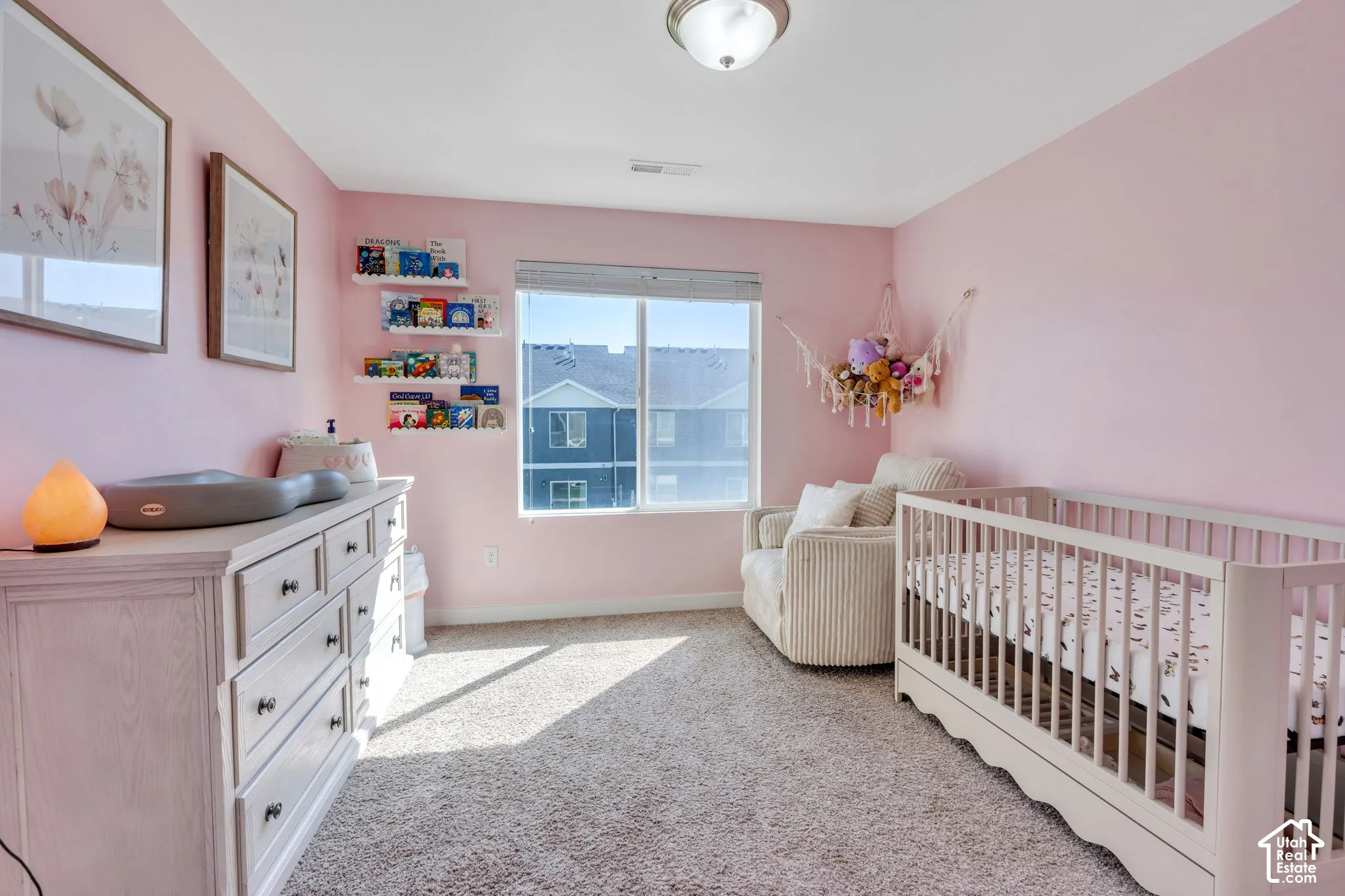 Carpeted room featuring a large window, flush mount ceiling light, and built-in wall shelving