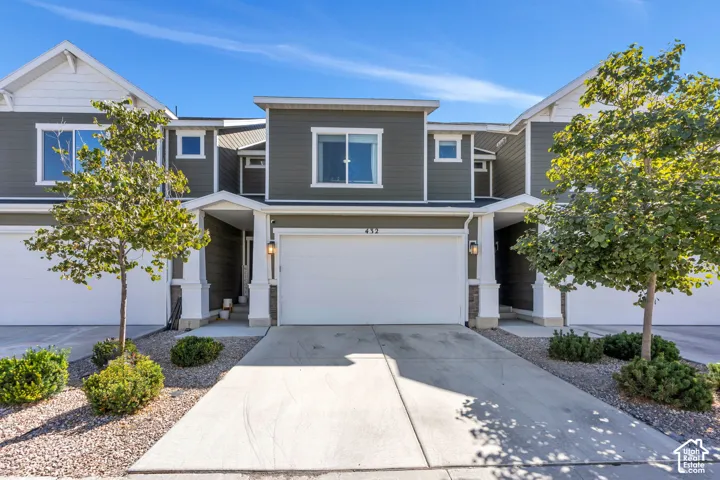 Multi-story exterior with horizontal siding, a prominent garage, a covered entryway, and mature landscaping