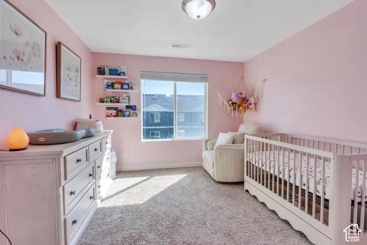 Carpeted room featuring a large window, flush mount ceiling light, and built-in wall shelving