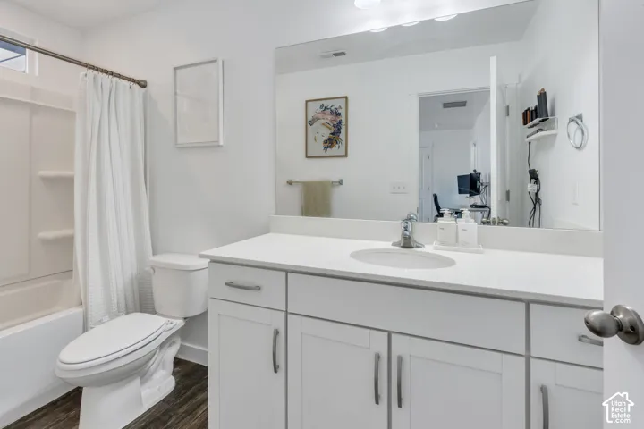 White vanity with integrated sink, chrome faucet, and expansive mirror