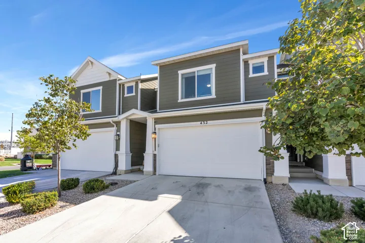 Contemporary architecture featuring a two-car garage, concrete driveway, and covered entry