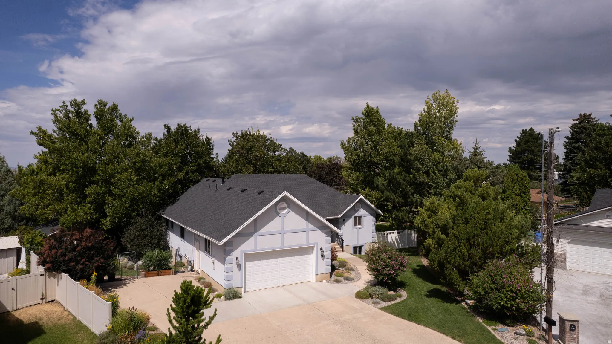 Light blue exterior with white trim, dark asphalt shingle roof, and a two-car garage