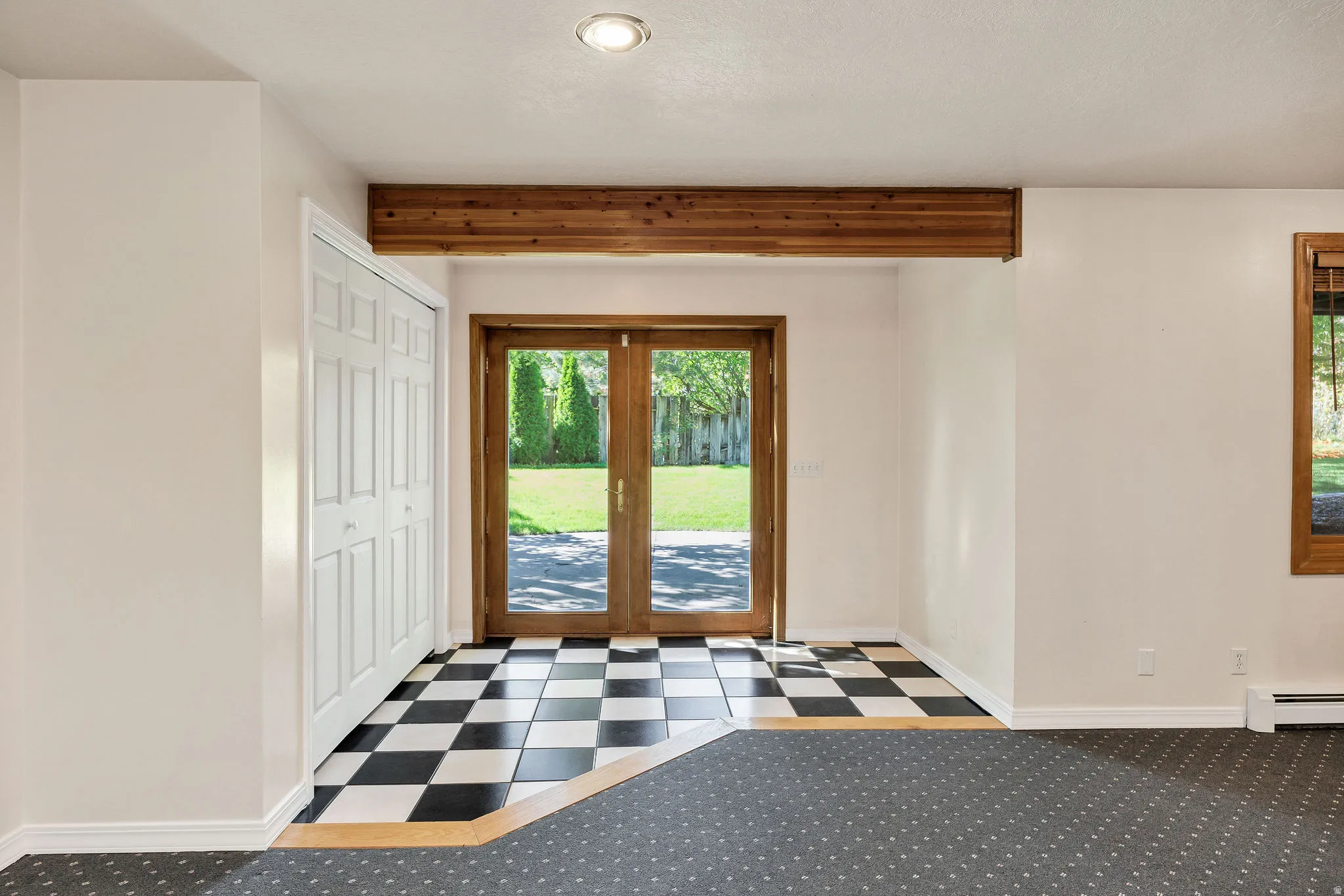 French doors, exposed wood beam, black and white checkerboard flooring, recessed lighting, and wall-to-wall carpeting