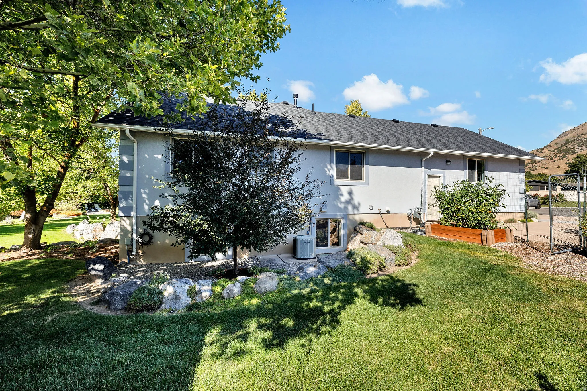 Manicured lawn with mature trees and rock landscaping