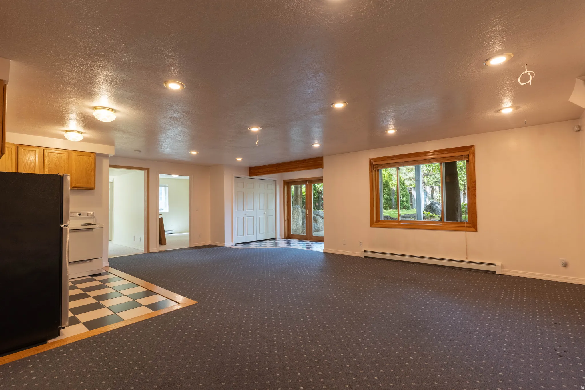 Recessed lighting, wood-framed window, two-panel bifold closet doors, wood-finish beam, and tile flooring