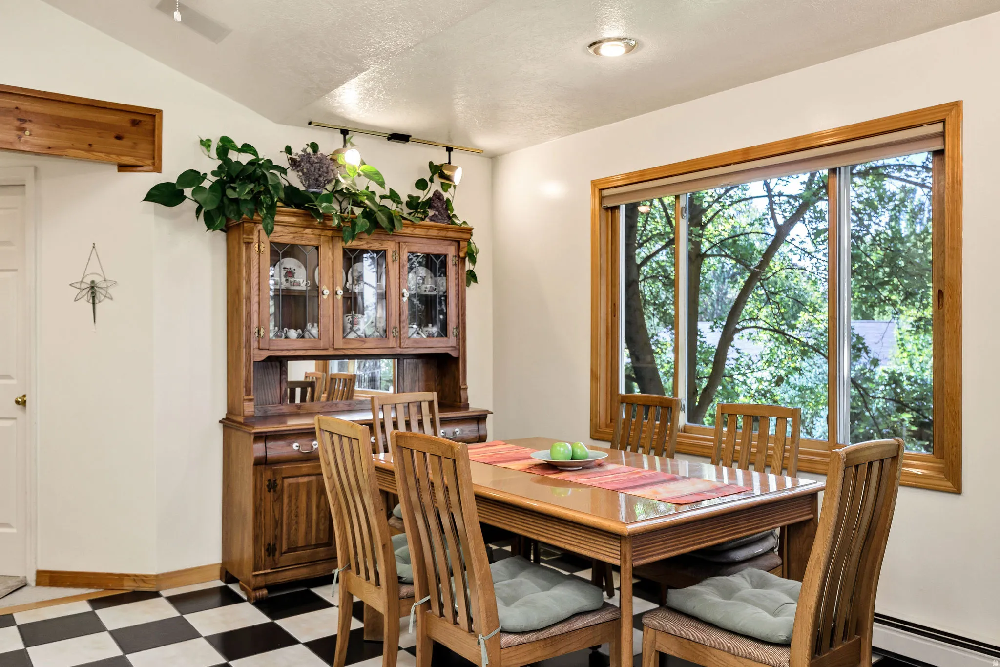 Checkered floor, large window with wood trim, recessed lighting, track lighting, white paneled door