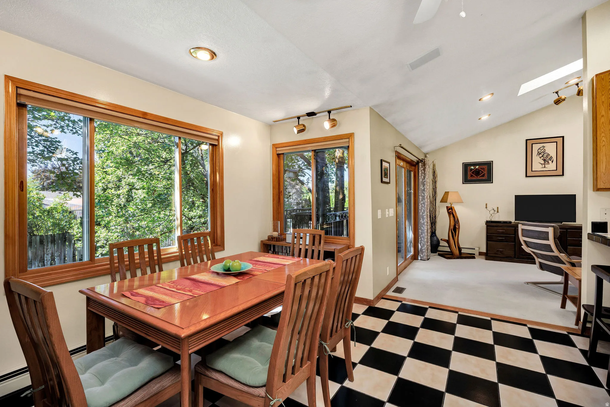 Black and white checkered floor, wood-trimmed windows, recessed lighting, vaulted ceiling, and a skylight