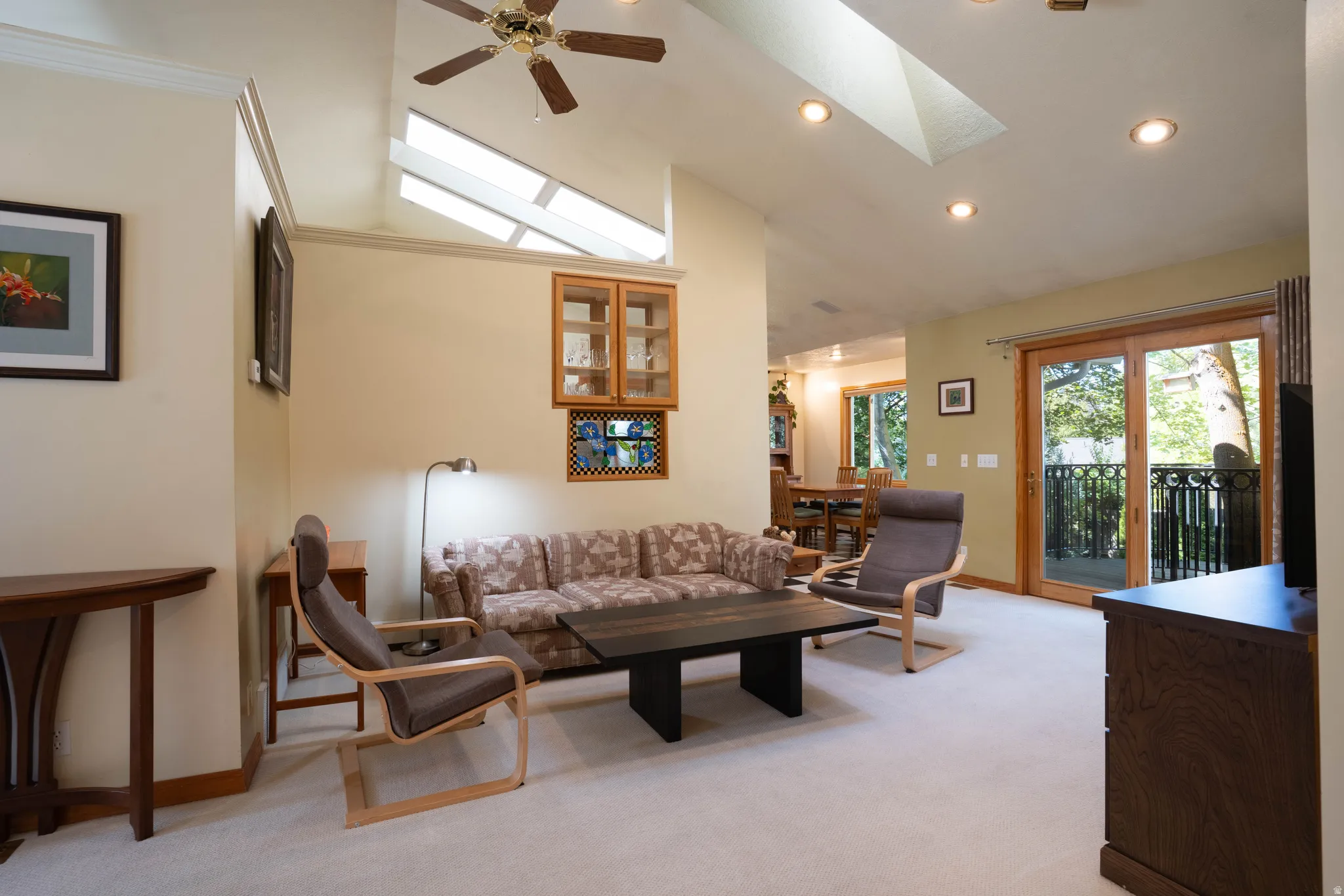 Vaulted ceilings with skylights, recessed lighting, and a ceiling fan