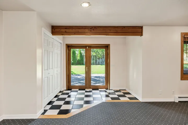 French doors, exposed wood beam, black and white checkerboard flooring, recessed lighting, and wall-to-wall carpeting