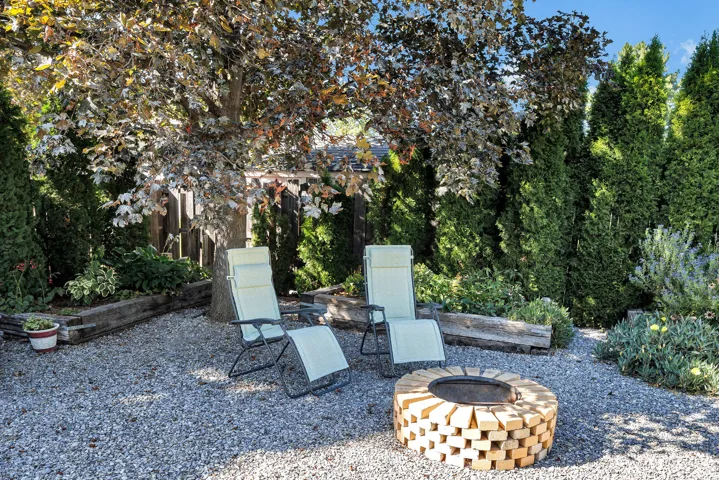 Gravel patio featuring a circular brick fire pit