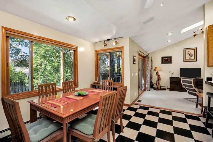 Black and white checkered floor, wood-trimmed windows, recessed lighting, vaulted ceiling, and a skylight