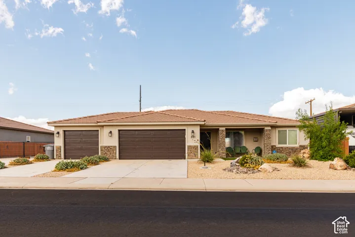 Stucco exterior with stone accents, tile roofing, and a two-car garage