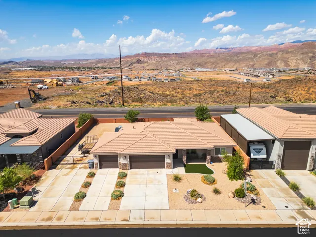 Tile roof, two-car garage, desert landscaping, gravel yard, and paved driveway
