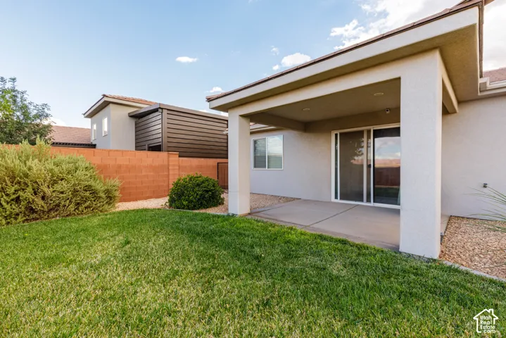 Covered patio with recessed lighting and concrete flooring, featuring sliding glass doors and an adjacent window