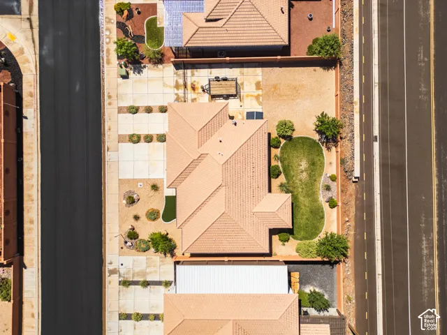 Tile roof structure with an expansive yard featuring a shaped lawn and desert landscaping