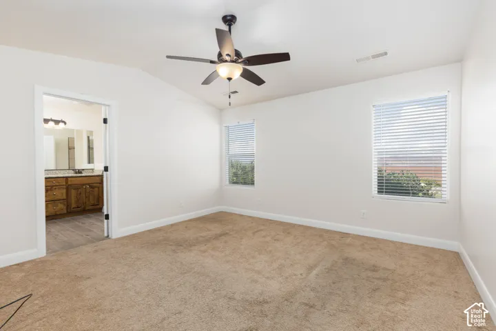 Spacious room with vaulted ceiling and ceiling fan