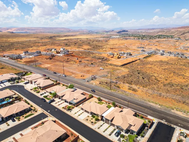 Residential development featuring a paved road, arid landscaping, and distant mountain scenery