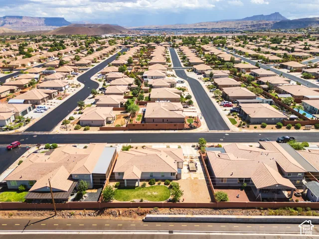 Residential community with uniform tile roofs and paved streets, featuring individual properties with desert-friendly landscaping