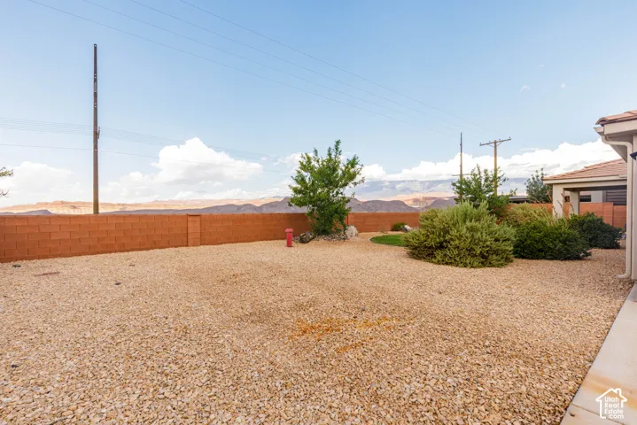Expansive gravel yard with low-maintenance landscaping and a solid block privacy wall