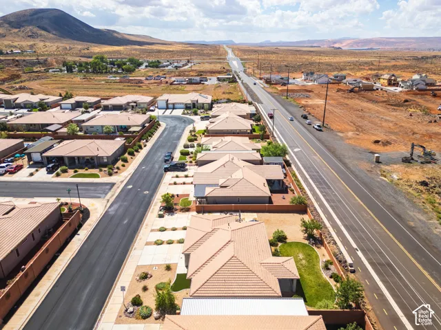 Residential development featuring a paved road, established homes, and undeveloped land