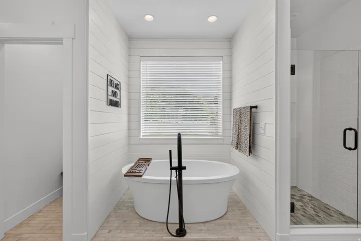 Freestanding soaking tub with a floor-mounted matte black faucet