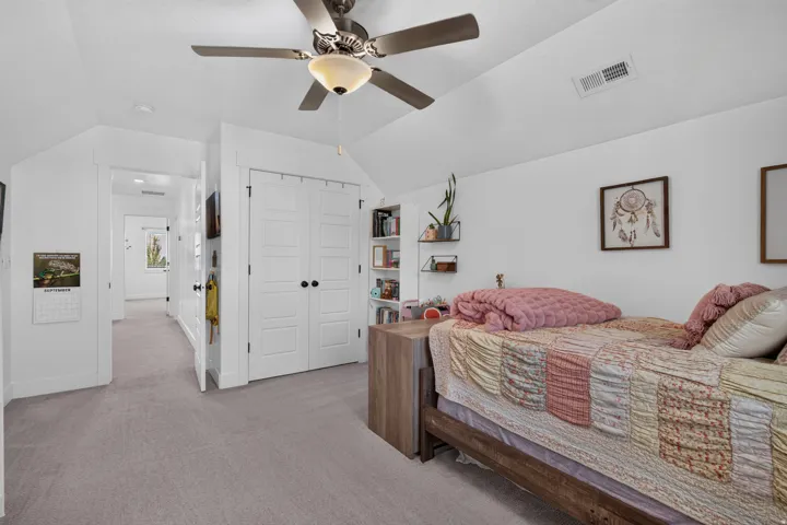 Recessed lighting, sloped ceiling, ceiling fan with integrated lighting, built-in shelving, and carpeted flooring