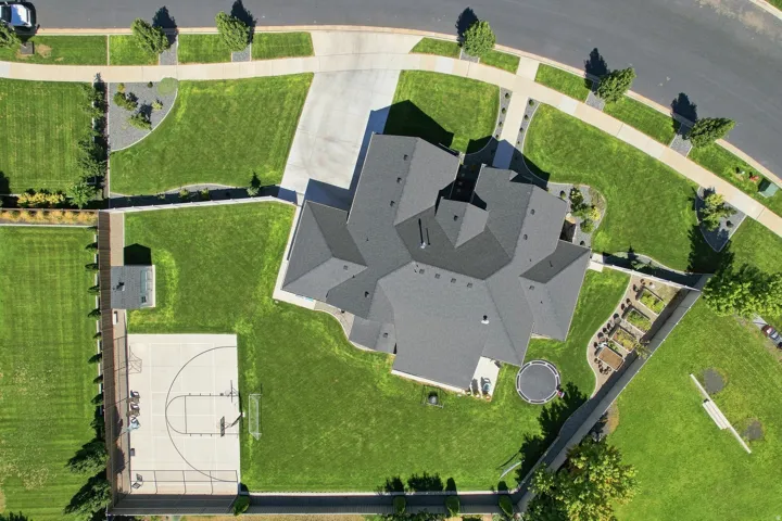Expansive grounds featuring a multi-sport court, a dedicated shed, and raised garden beds