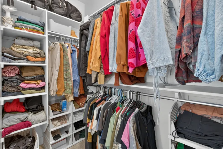 Built-in closet organization system featuring multiple shelving units and chrome hanging rods