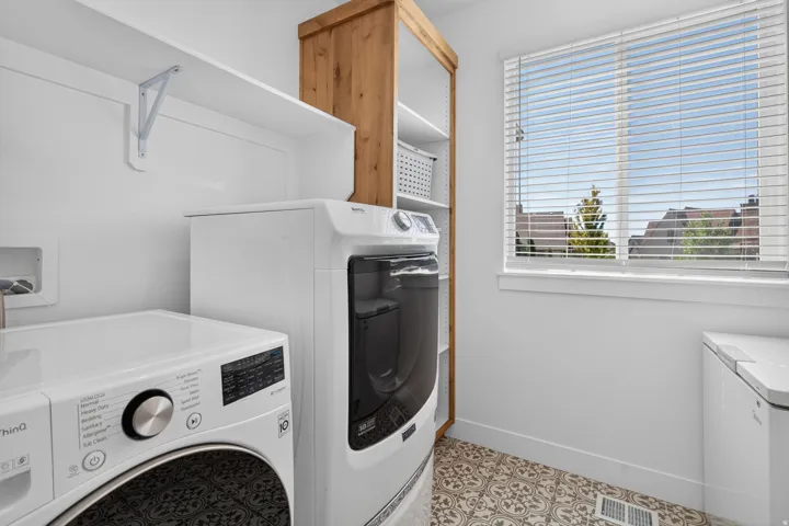 White walls with a window, wood-finish shelving, and patterned floor tiles