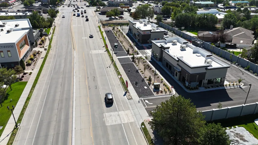 Commercial building with contemporary architecture, dedicated parking area, and a paved drive-through lane