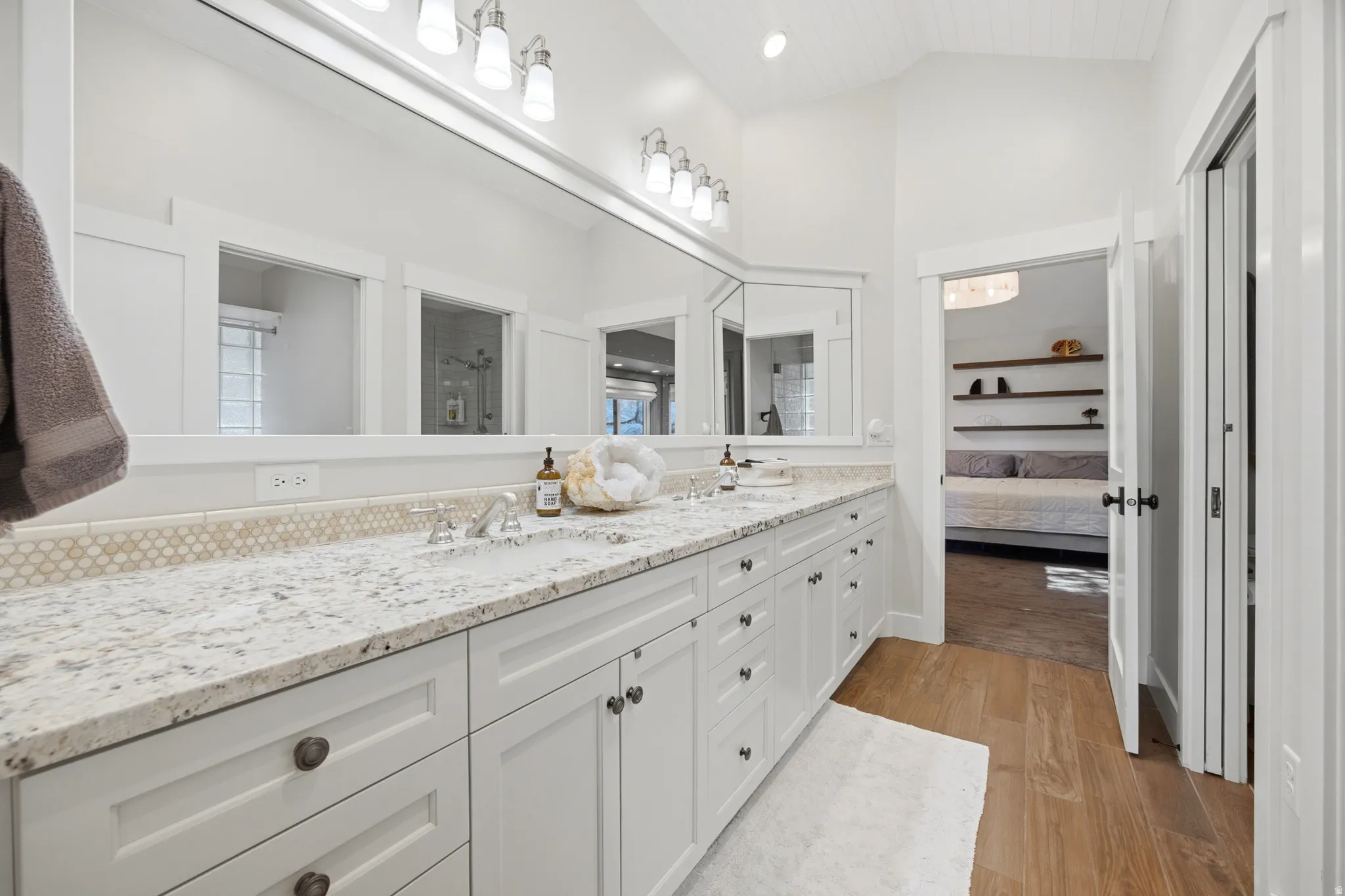 Dual vanity with white cabinetry and dark hardware
