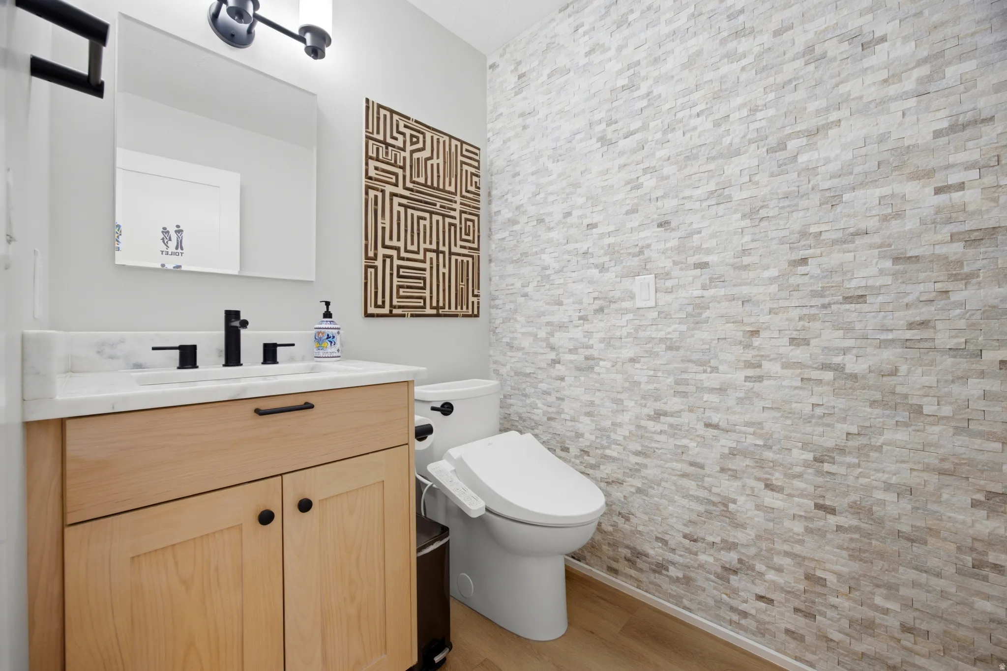 Light wood-finish vanity with a white countertop and matte black fixtures