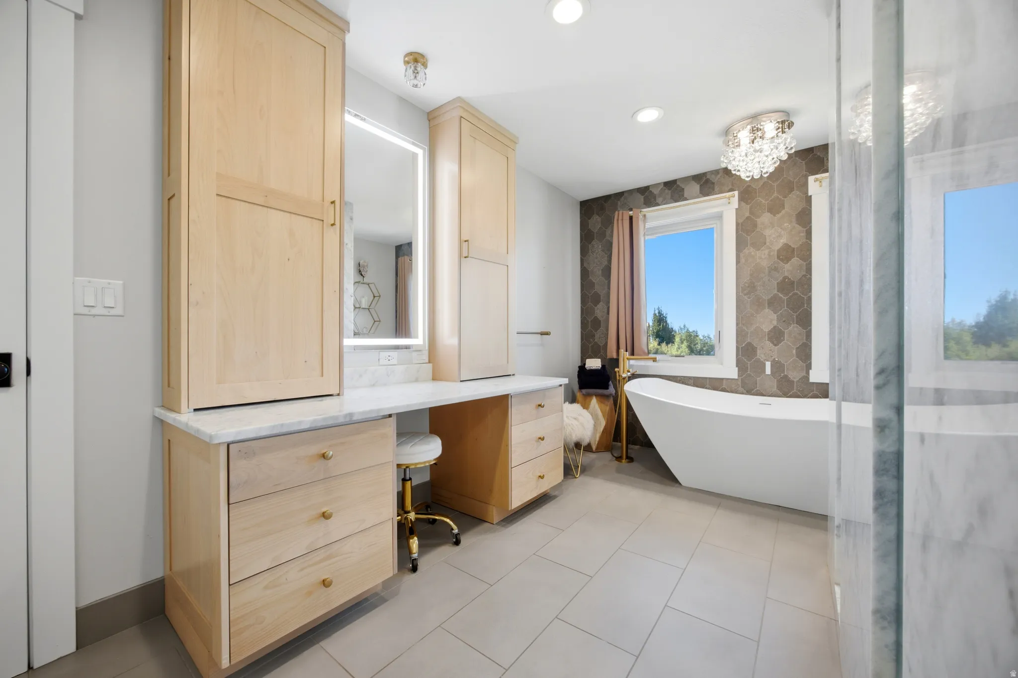 Light wood-finish cabinetry with a white countertop and integrated vanity area