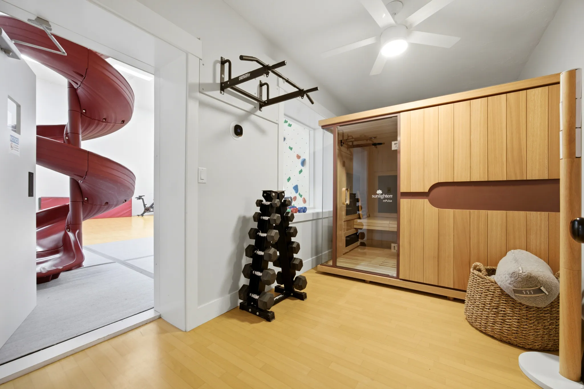 Wood-finish flooring, built-in sauna, ceiling fan, and white walls