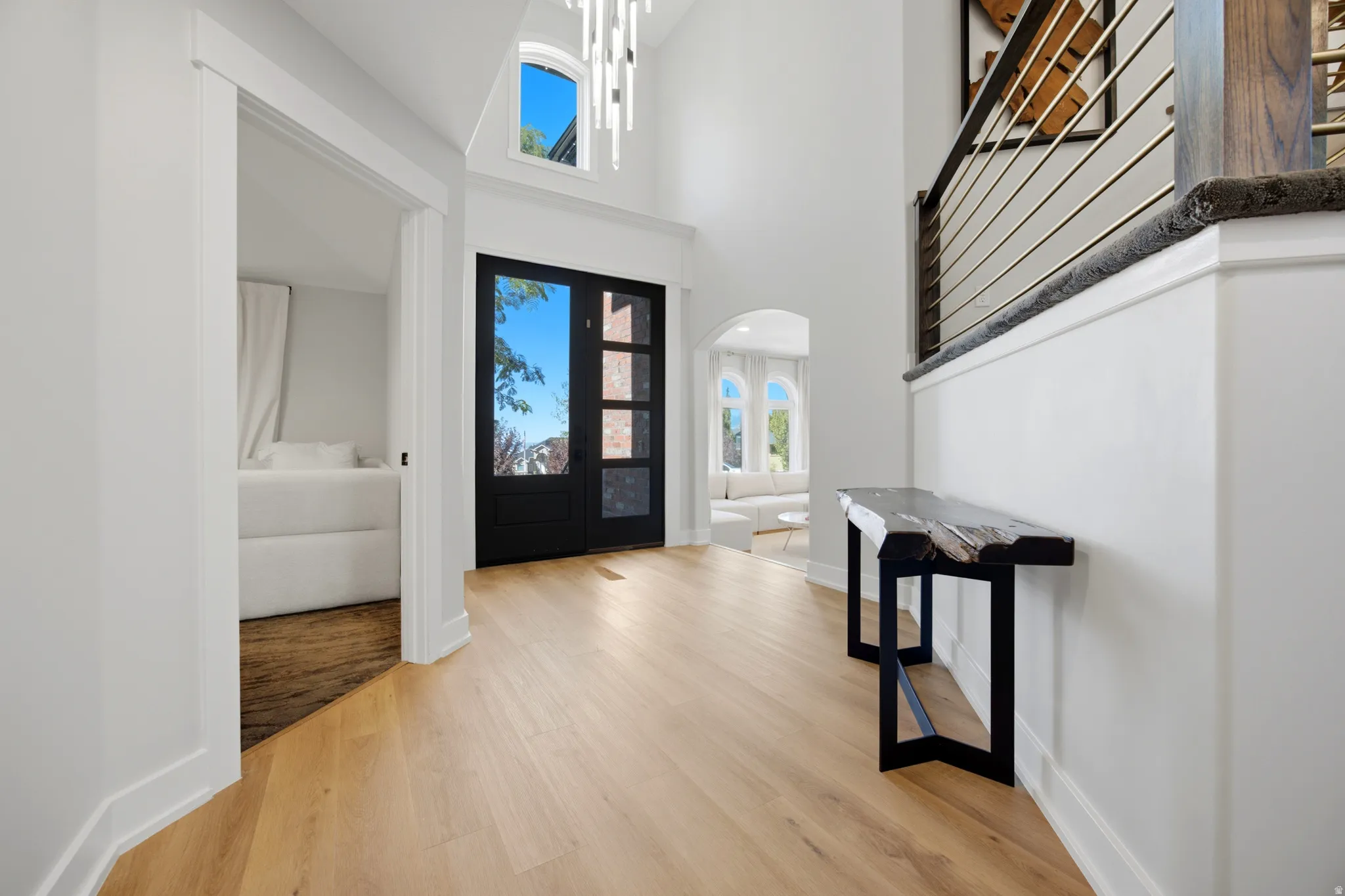 Vaulted entryway with wood-finish flooring, a two-story ceiling, and a modern chandelier