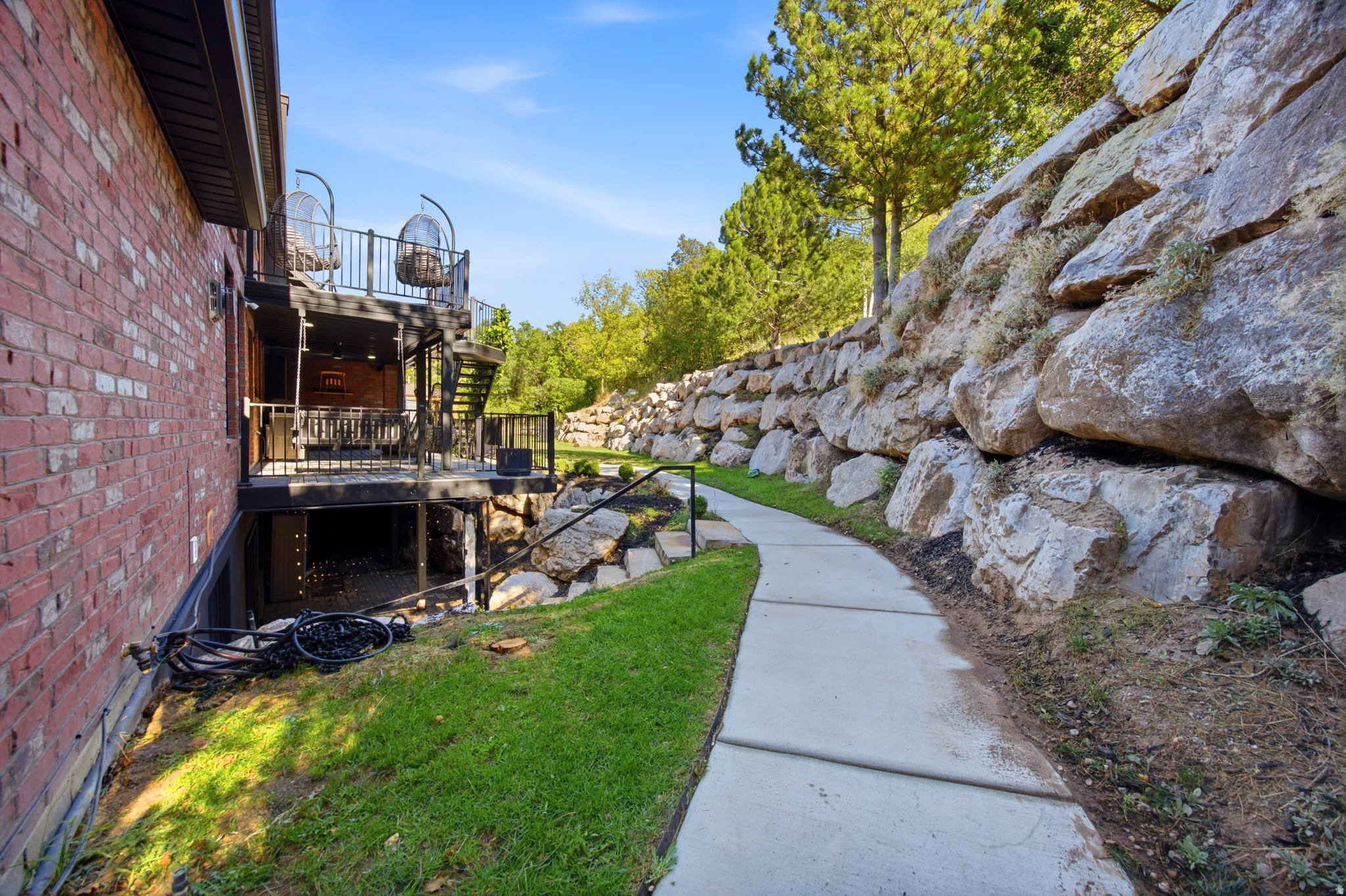 Brick exterior with multi-level decks and a stone retaining wall